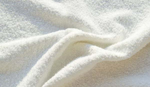 White Terry bath towel, texture with pleats, background.